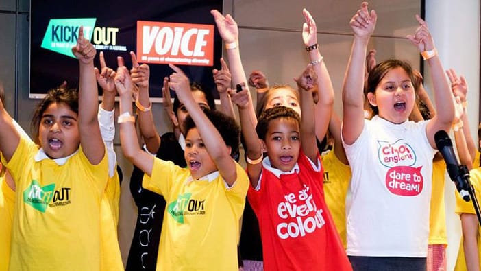 Choir singers clap their hands during Everycolours England anthem